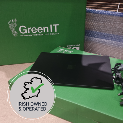 A black Microsoft Surface laptop sits on a green Microsoft Surface box, with a large green GreenIT box behind it. A circular badge in the foreground reads 'IRISH OWNED & OPERATED' with a green checkmark.
