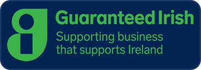 A blue badge with rounded corners featuring a green stylized 'g' icon and the text 'Guaranteed Irish Supporting business that supports Ireland' in green.